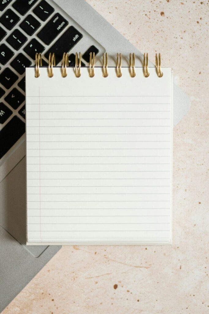 Bloc de notas sobre un portátil junto al teclado